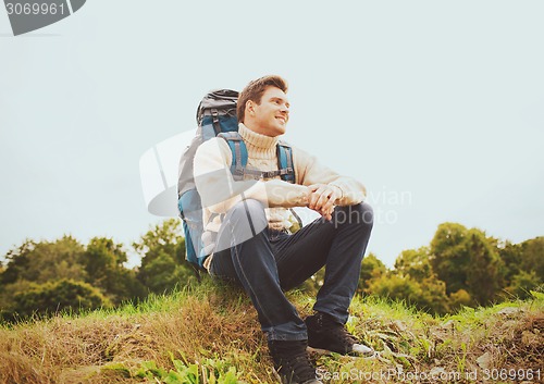 Image of smiling man with backpack hiking