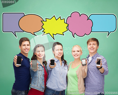 Image of happy friends showing blank smartphones screens