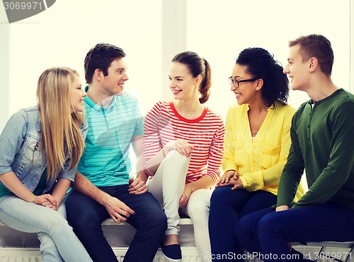 Image of five smiling teenagers having fun at home