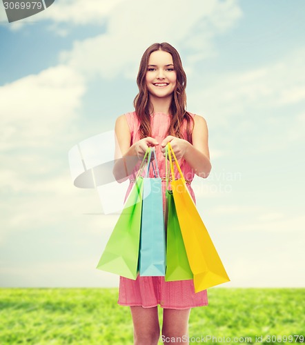Image of smiling woman in dress with many shopping bags