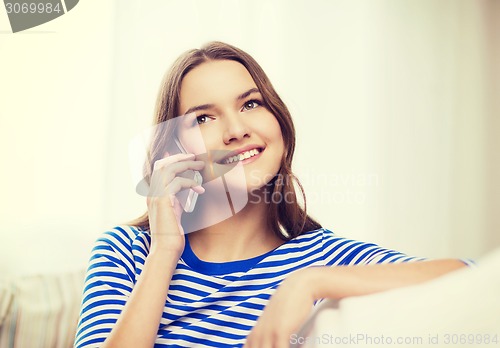 Image of smiling teenage girl with smartphone at home