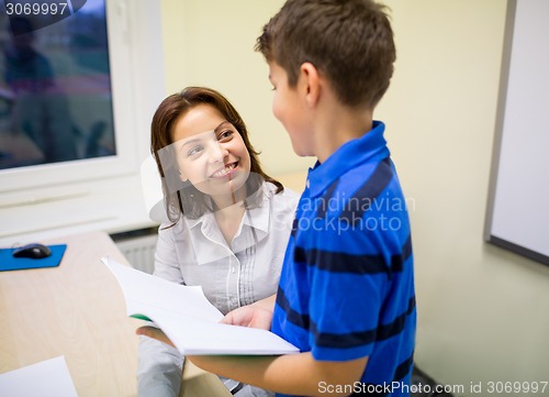 Image of school boy with notebook and teacher in classroom