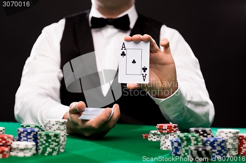 Image of holdem dealer with playing cards and casino chips