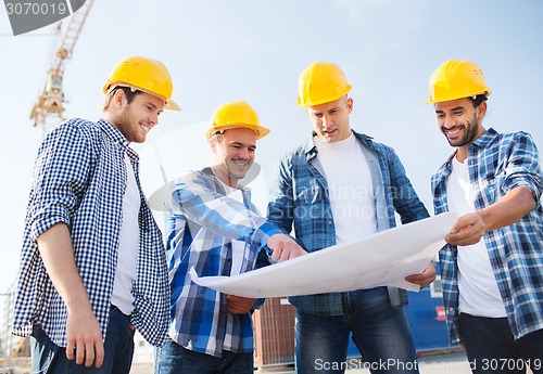 Image of group of builders with tablet pc and blueprint