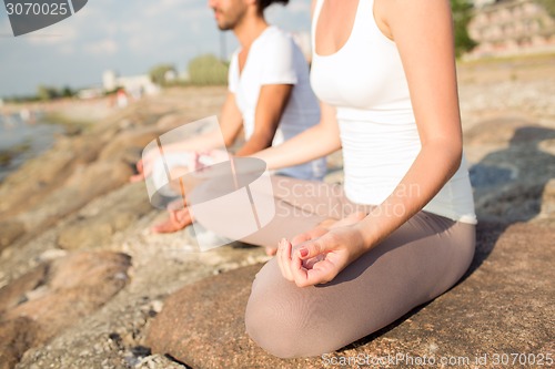 Image of close up of couple making yoga exercises outdoors