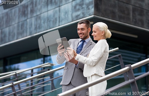 Image of smiling businessmen with tablet pc outdoors