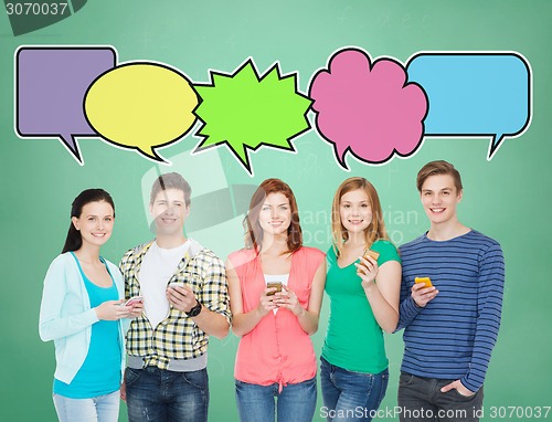 Image of happy friends showing blank smartphones screens