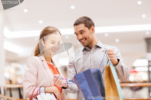 Image of happy young couple with shopping bags in mall