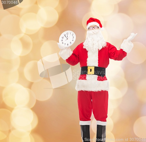 Image of man in costume of santa claus with clock