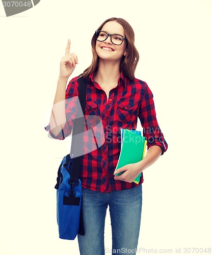Image of smiling female student with bag and notebooks