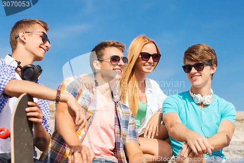 Image of group of smiling friends sitting on city street