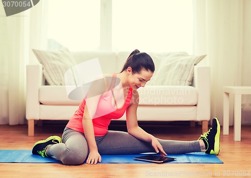 Image of smiling teenage girl streching on floor at home