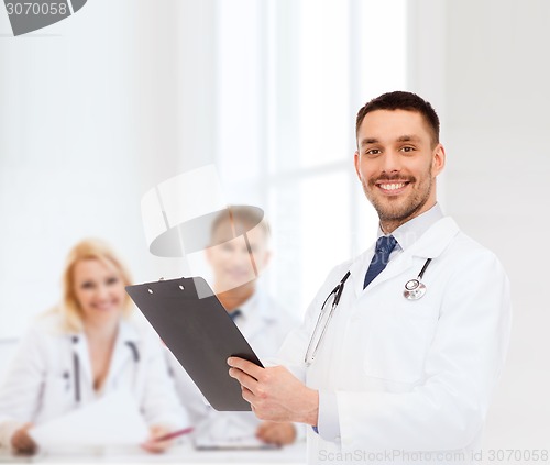 Image of smiling male doctor with clipboard and stethoscope