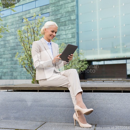 Image of smiling businesswoman with tablet pc outdoors