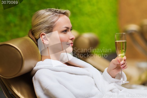 Image of beautiful young woman drinking champagne at spa