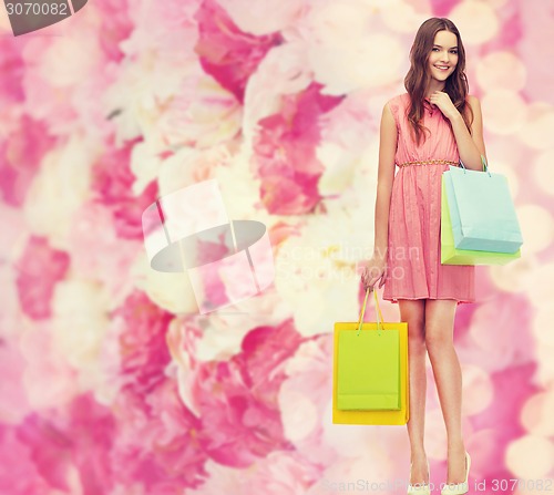 Image of smiling woman in dress with many shopping bags