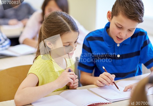 Image of group of school kids writing test in classroom