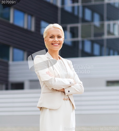 Image of young smiling businesswoman with crossed arms