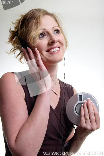 Image of Smiling woman listening to music