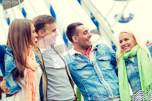 Image of group of smiling friends in amusement park