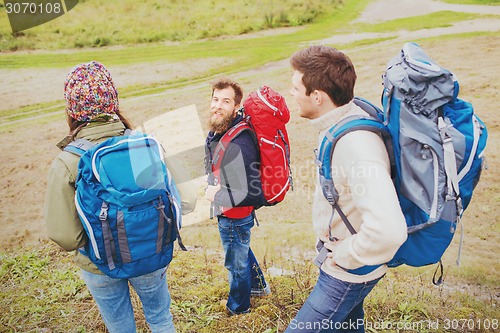 Image of group of smiling friends with backpacks hiking