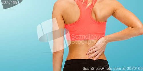 Image of close up of sporty woman touching her back