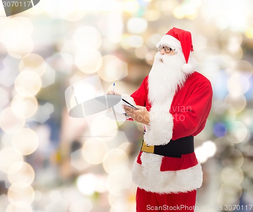 Image of man in costume of santa claus with notepad