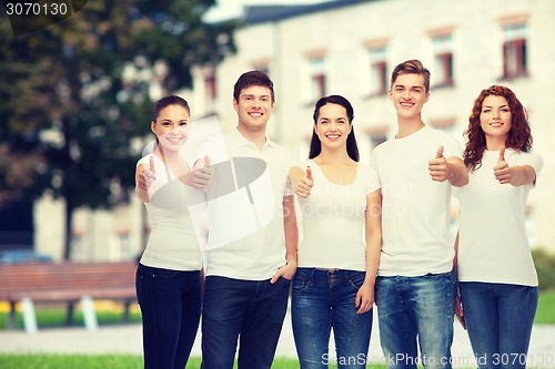Image of smiling teenagers in t-shirts showing thumbs up