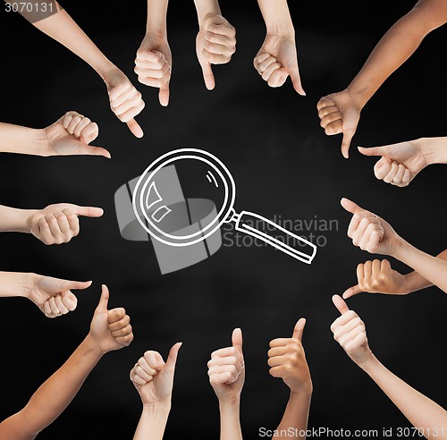 Image of hands showing thumbs up in circle over magnifier