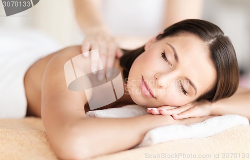 Image of beautiful woman in spa salon getting massage