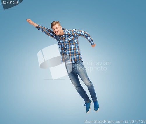 Image of smiling young man jumping in air