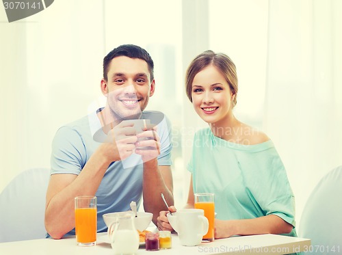 Image of smiling couple having breakfast at home