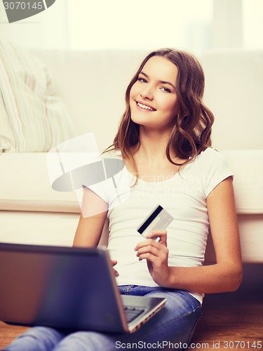 Image of smiling teenage girl with laptop and credit card