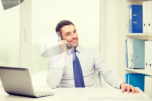 Image of businessman with laptop and smartphone at office