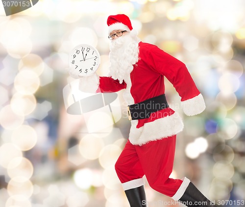 Image of man in costume of santa claus with clock