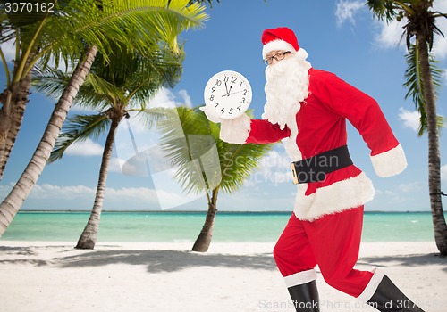 Image of man in costume of santa claus with clock