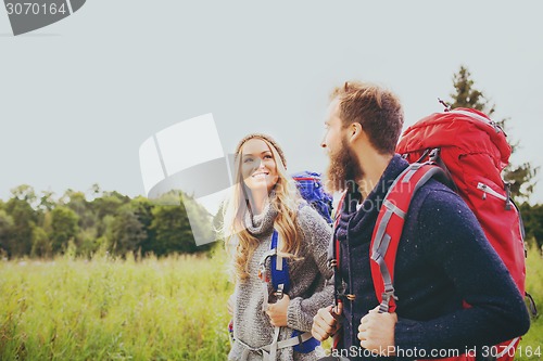 Image of smiling couple with backpacks hiking