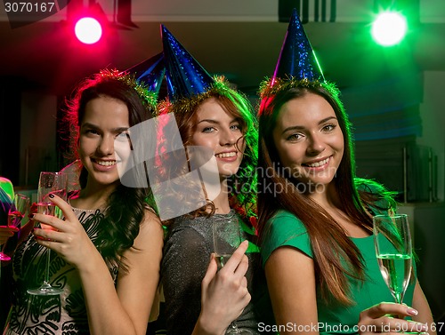 Image of smiling friends with glasses of champagne in club