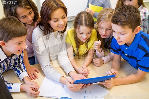 Image of group of kids with teacher and tablet pc at school