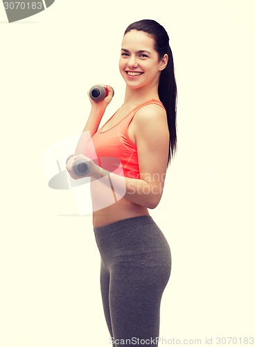 Image of young sporty woman with light dumbbells