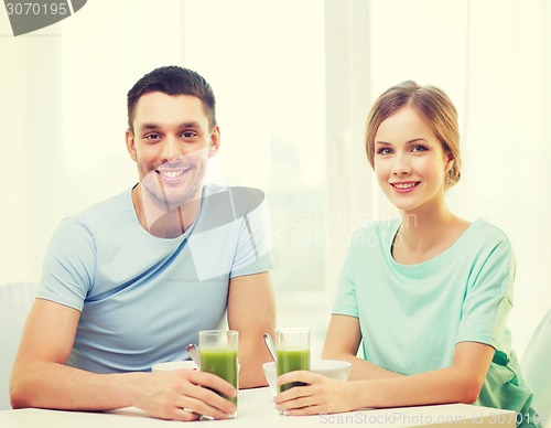 Image of smiling couple having breakfast at home