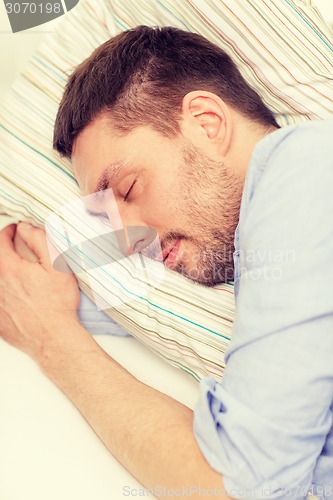 Image of calm young man lying on sofa at home