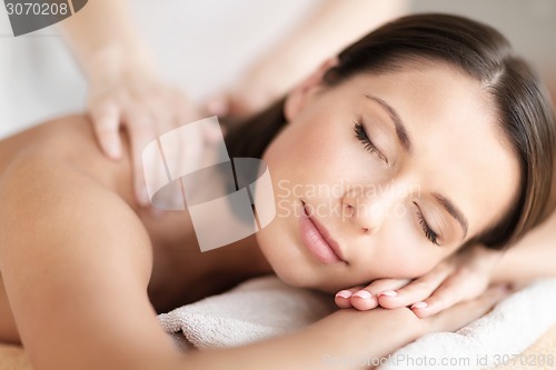 Image of beautiful woman in spa salon getting massage