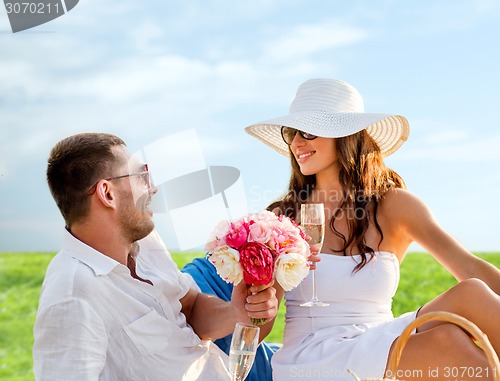 Image of smiling couple drinking champagne on picnic