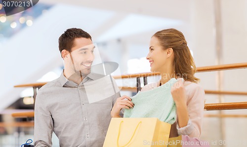 Image of happy young couple with shopping bags in mall