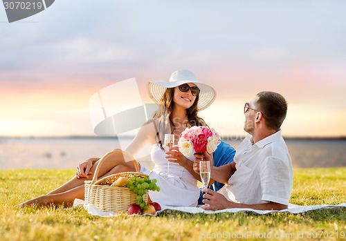 Image of smiling couple drinking champagne on picnic