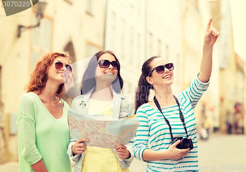 Image of smiling teenage girls with map and camera