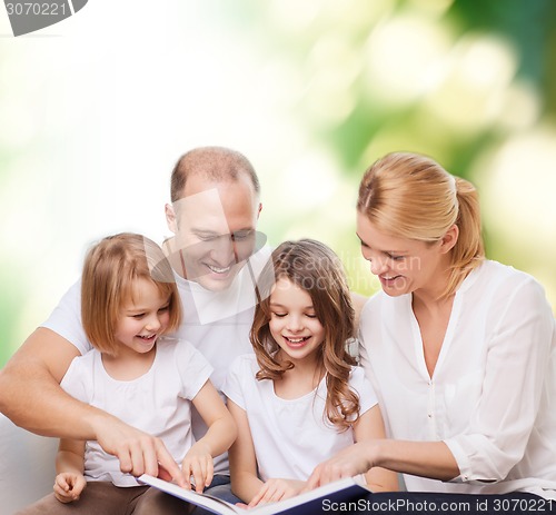 Image of happy family with book at home