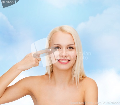 Image of beautiful woman touching her eye area