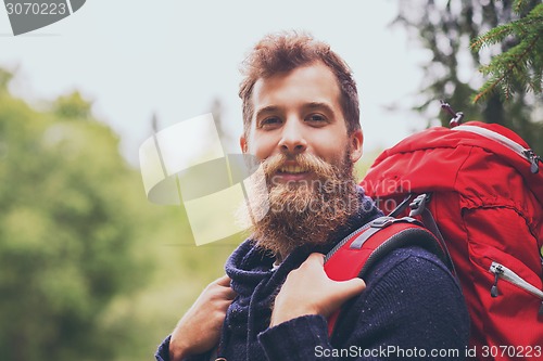 Image of smiling man with beard and backpack hiking